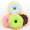 Blueberry, Strawberry, Lime and Chocolate Squeaky Donut Plush Toys placed on an empty background