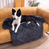 A Border Collie relaxing on a Charcoal Calming Cuddle Furniture Protector placed on a couch